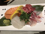 A vibrant sashimi plate featuring thinly sliced salmon, tuna, and yellowtail.