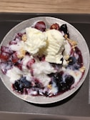 A bowl of creamy gelato topped with fresh berries.