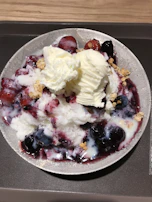 Mixture of natural and pistachio frozen yogurt topped with blueberries and shredded coconut.