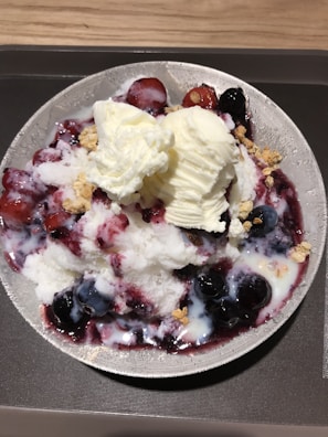 A bowl of creamy gelato topped with fresh berries.