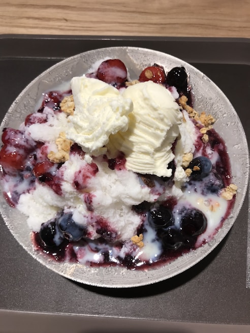 A vibrant bowl of mixed berry sorbet topped with fresh berries and mint leaves