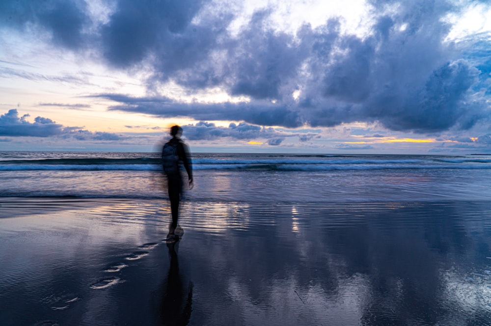 a person walking on a beach near the ocean