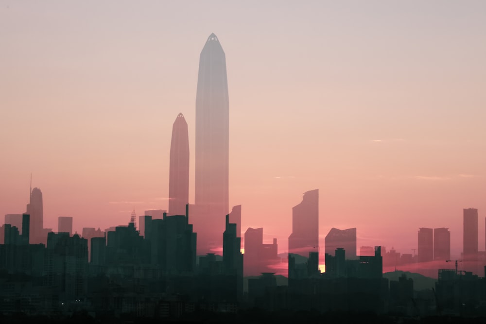 a city skyline with tall buildings at sunset