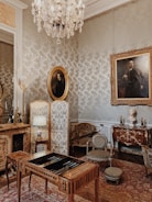 A warmly lit room showcasing an elegant collection of antique furniture and tapestries
