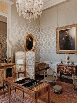 A warmly lit room showcasing an elegant collection of antique furniture and tapestries