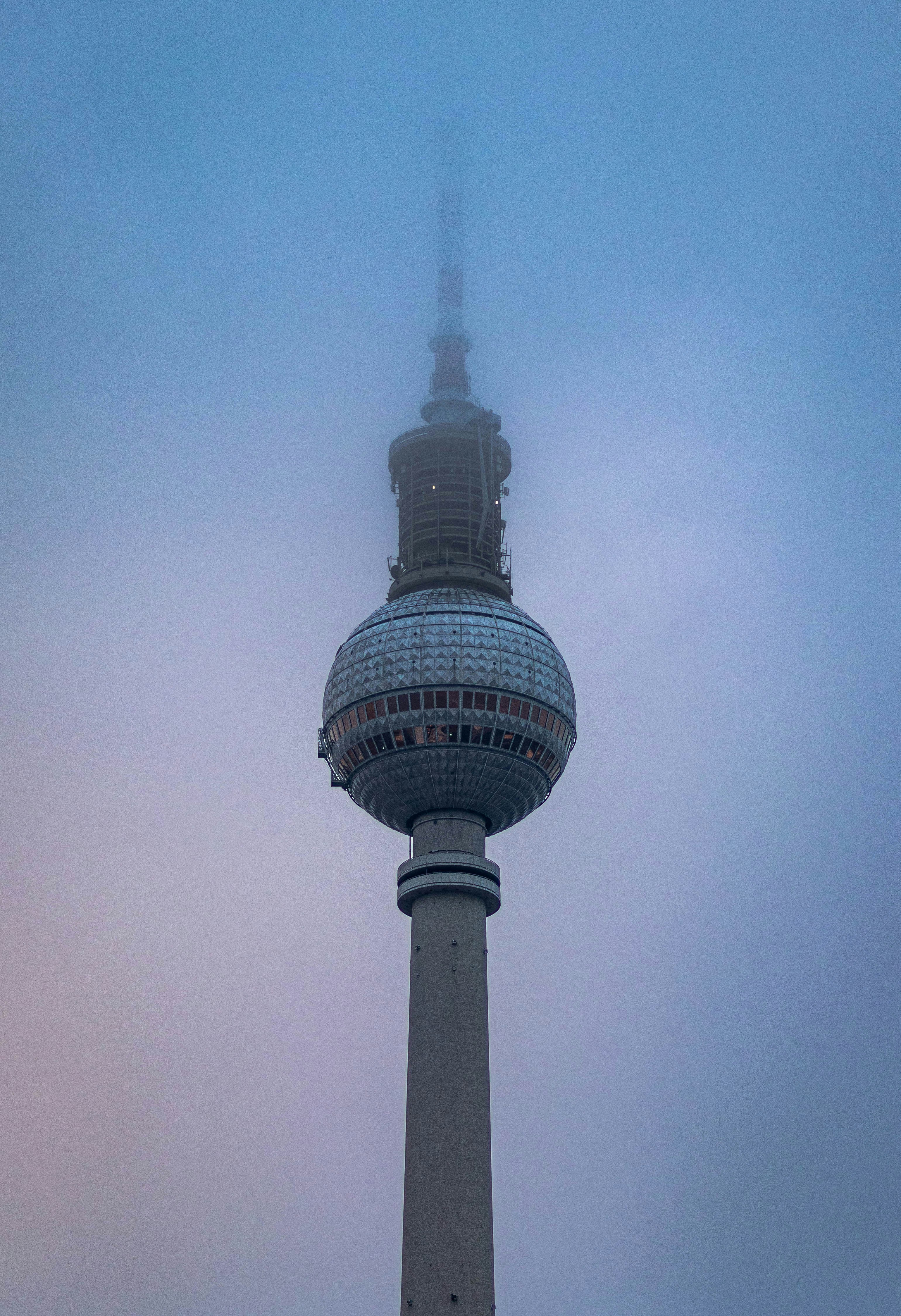 uma torre muito alta com um relógio muito alto ao seu lado