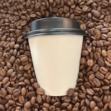 A vibrant coffee tumbler with a spill-proof lid, surrounded by fresh coffee beans.