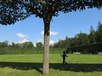 A small child playing happily under the shade of a tree near the charity’s shelter.