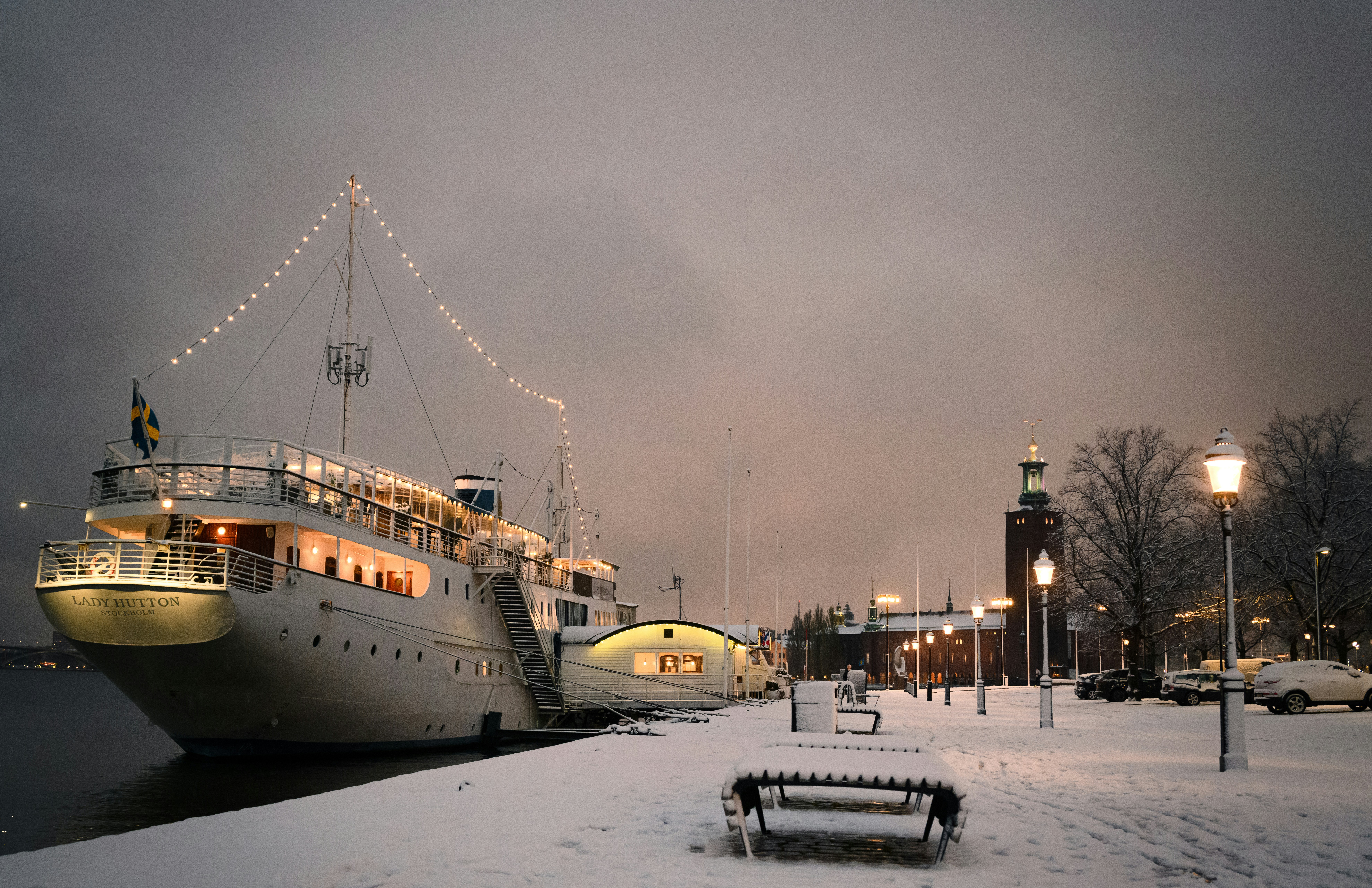 a boat docked at a pier in the snow