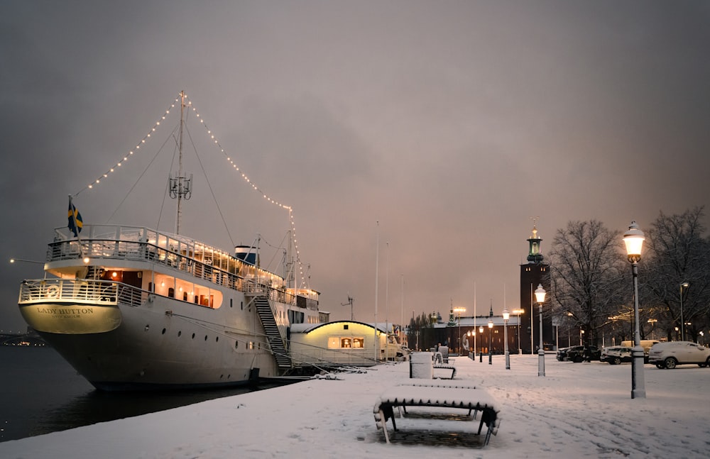 a boat docked at a pier in the snow