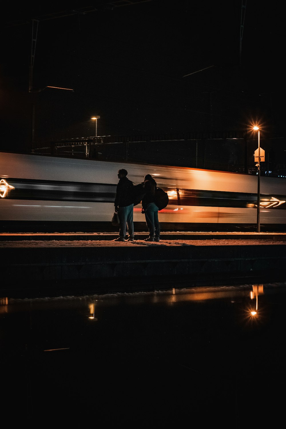 a couple of people standing next to a train