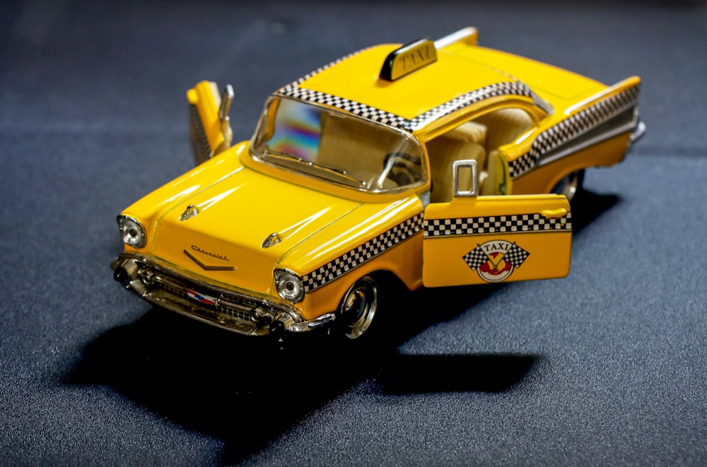 a yellow toy truck with a taxi cab