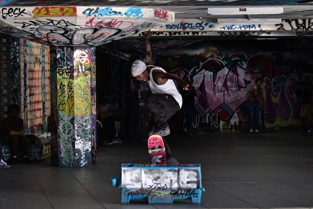 a man riding a skateboard on top of a blue box