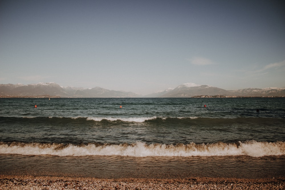 a body of water with mountains in the background