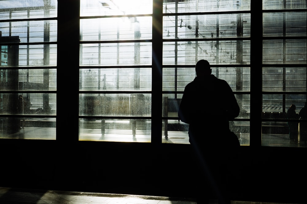 a man standing in front of a large window