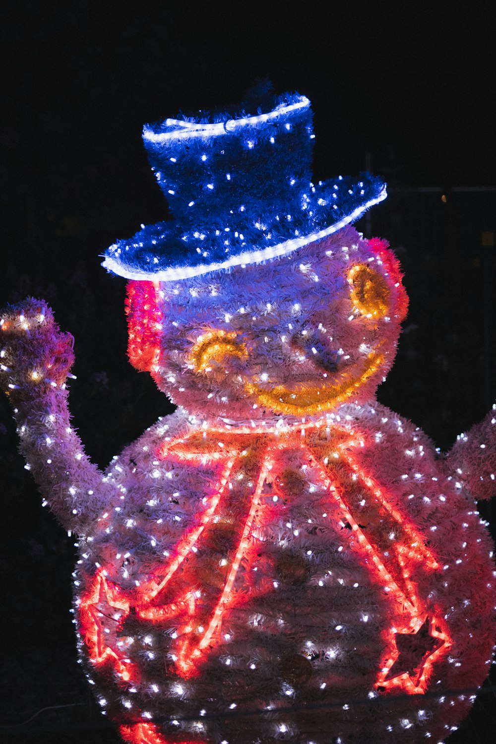 a lighted snowman with a top hat and cane