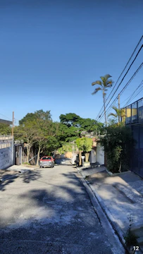View of a quiet street with residential houses and trees.