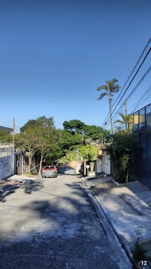 A quiet residential plot surrounded by trees and open skies.