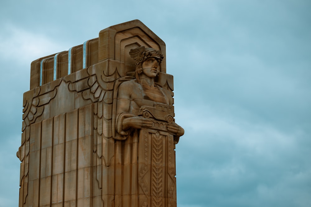 a statue of a woman sitting on top of a pillar