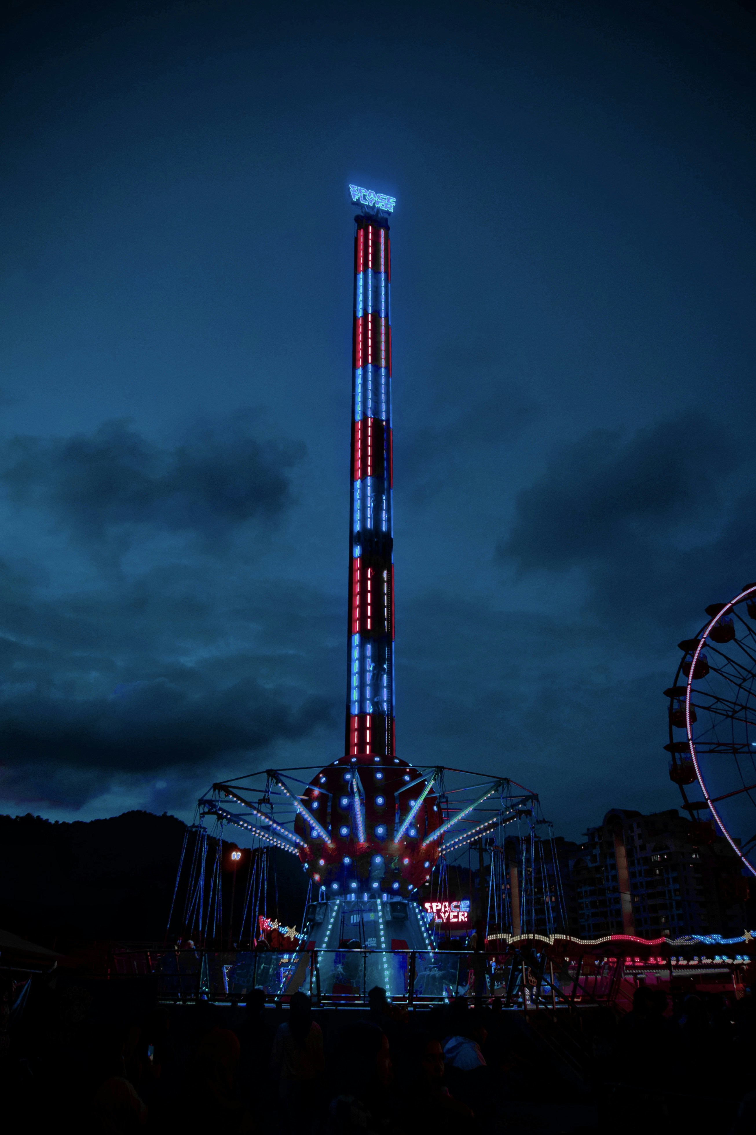 a ferris wheel lit up with red, white and blue lights