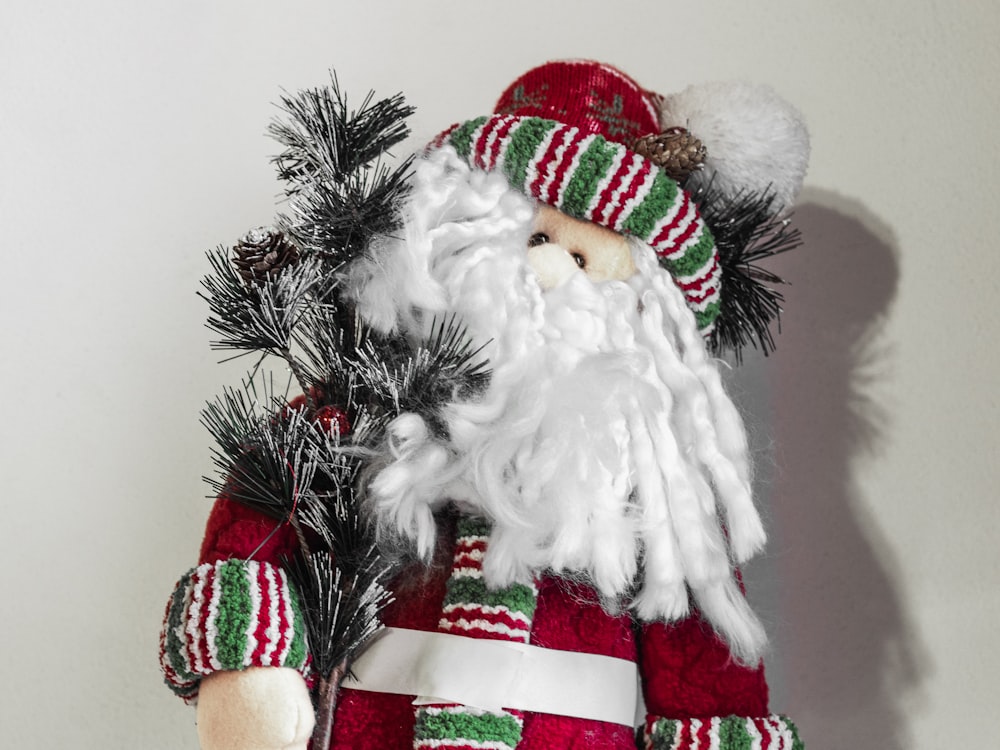 a christmas decoration of a santa clause holding a pine branch