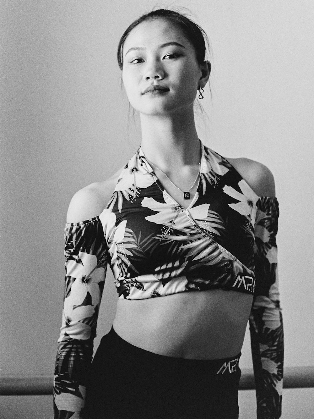 a black and white photo of a woman in a crop top
