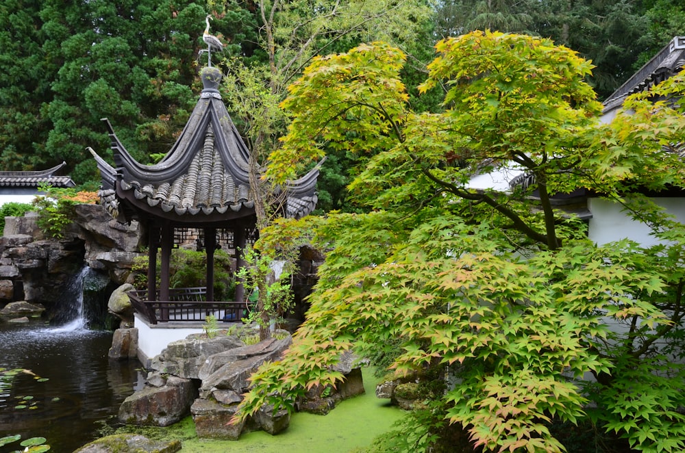 a gazebo in the middle of a pond surrounded by trees