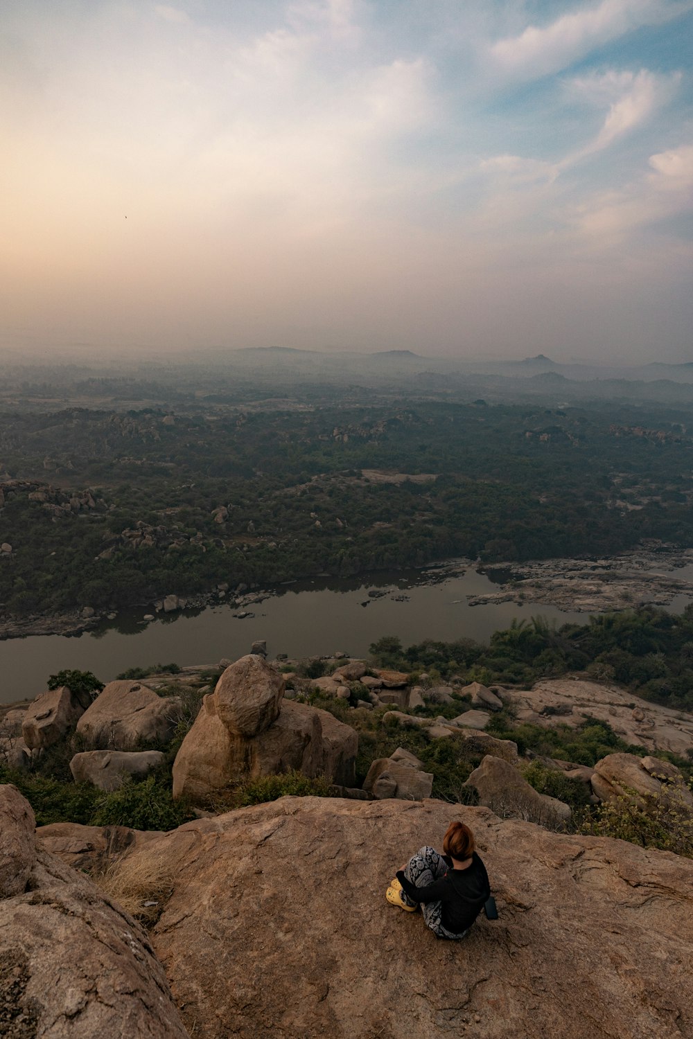 a person sitting on top of a large rock