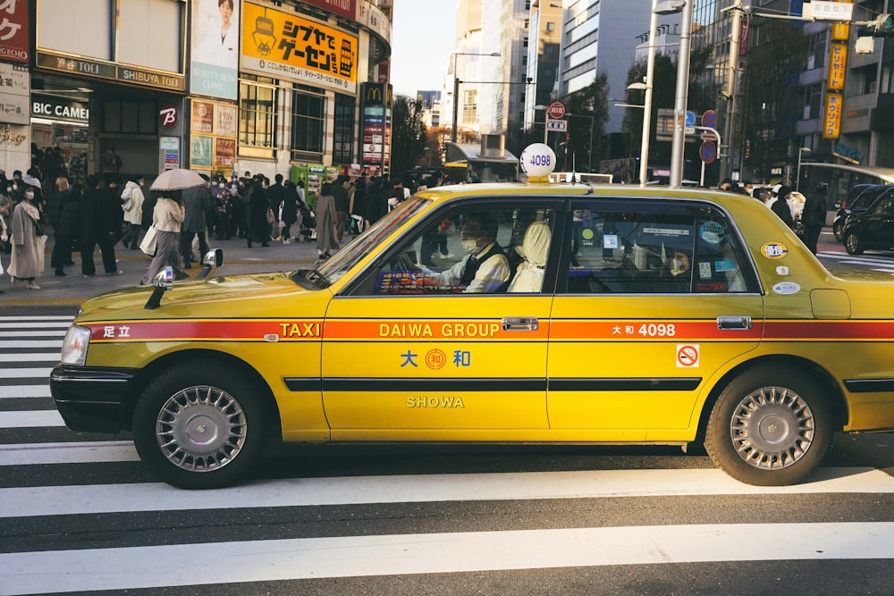 Un taxi giallo che guida lungo una strada vicino a edifici alti