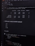 A computer screen displaying a coding interface with Python code related to machine learning. The code imports libraries like sklearn and deals with model metrics such as precision and recall. A classification report is shown along with a section titled 'Different meta model trained' listing various models like DT, RF, LR, and XGB. Below, there is code for tuning an XGB model using GridSearchCV.