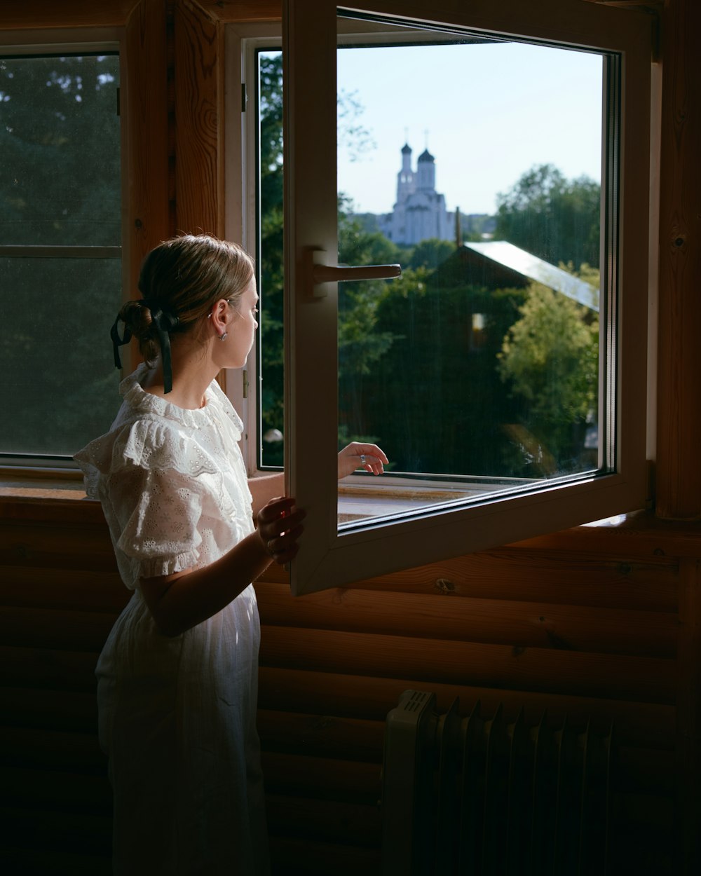 a young girl looking out a window at the city