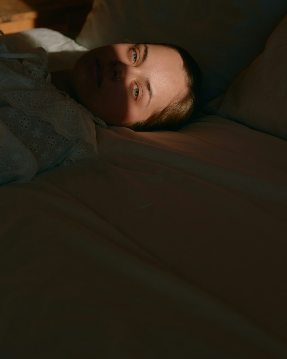 a woman laying in bed under a blanket