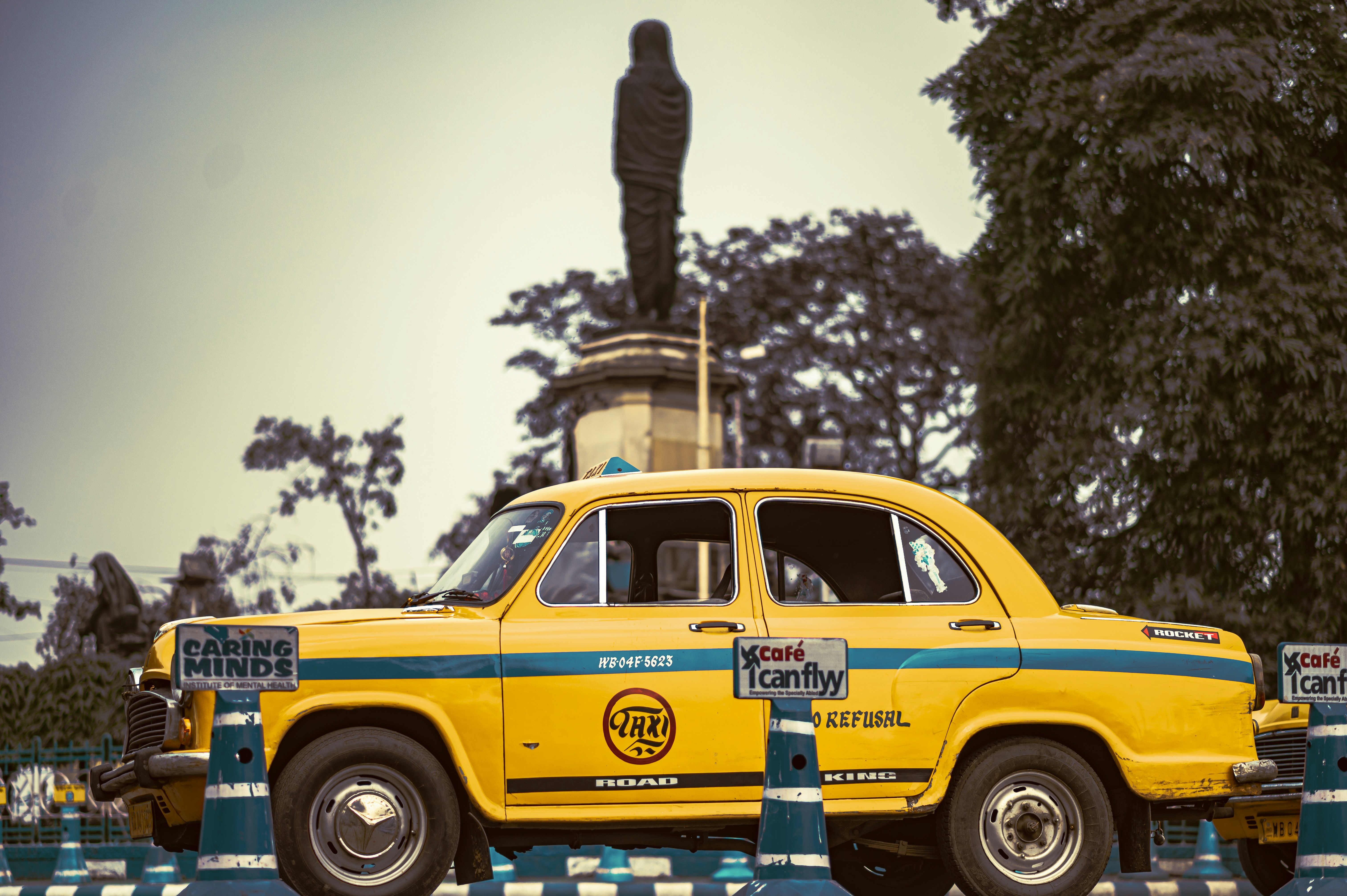 Un taxi amarillo estacionado frente a una estatua