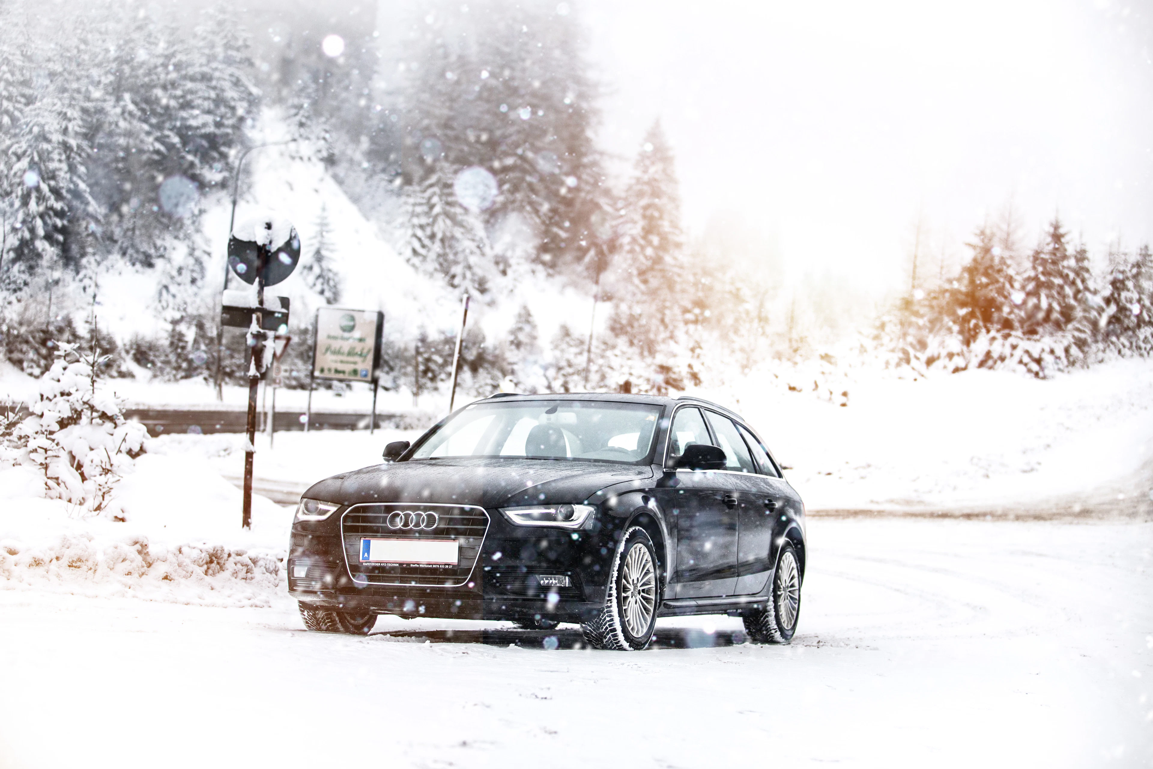 Black car driving on a snow-covered road