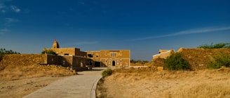 a dirt path leading to a building in the desert