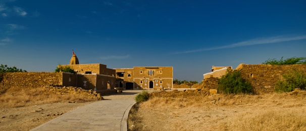 a dirt path leading to a building in the desert