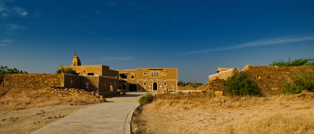 a dirt path leading to a building in the desert