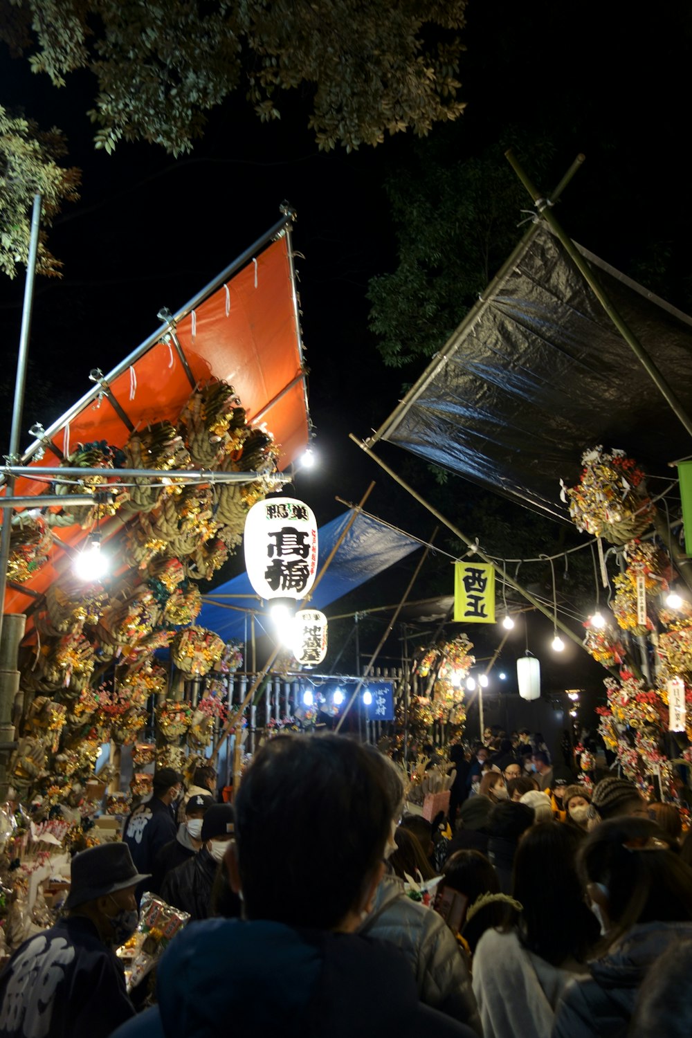 a crowd of people standing around a tent at night