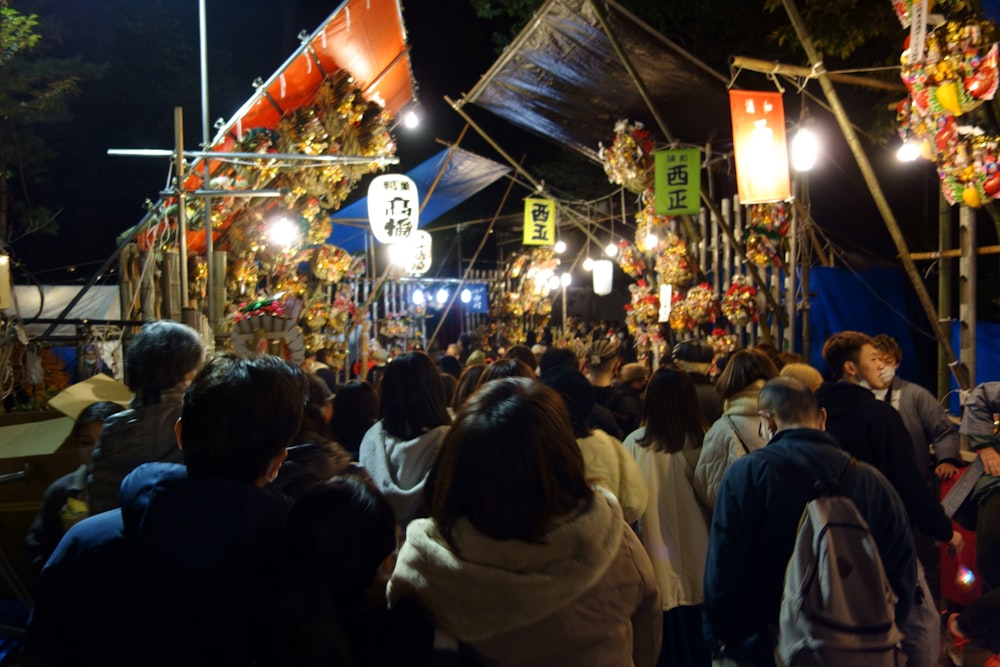 a crowd of people walking down a street at night