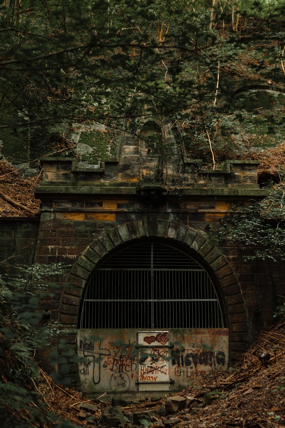 an old brick tunnel with graffiti on it