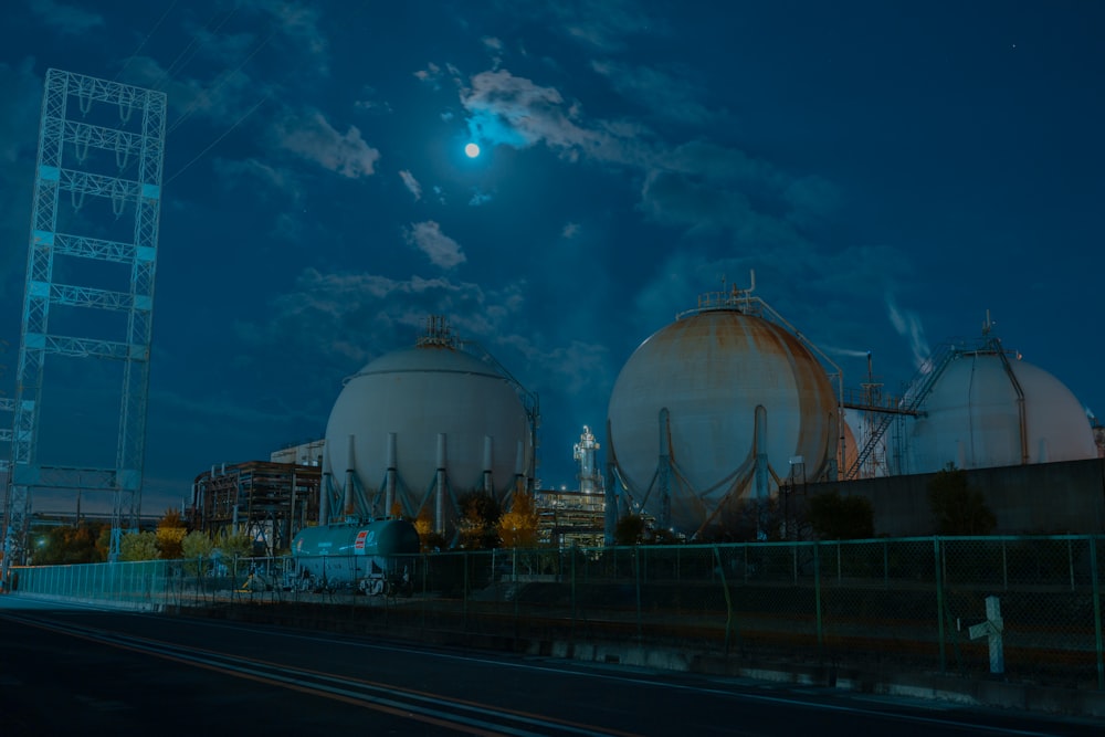 a full moon is seen over a large industrial area