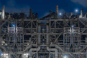Nighttime image of illuminated water pipes and fire protection systems installed in an urban area.