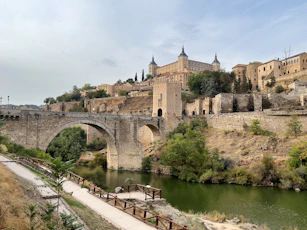 a bridge over a river with a castle in the background