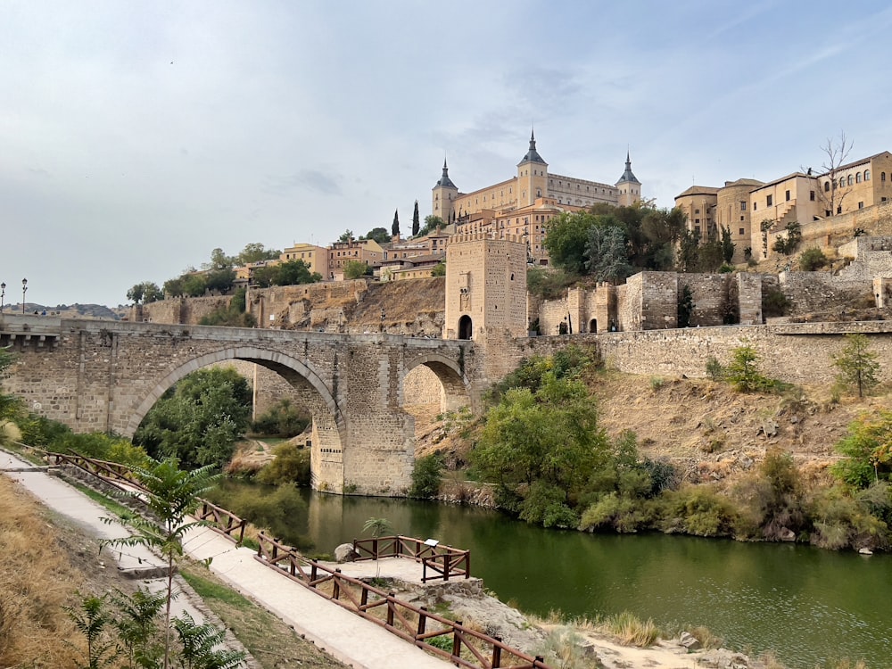 un pont sur une rivière avec un château en arrière-plan