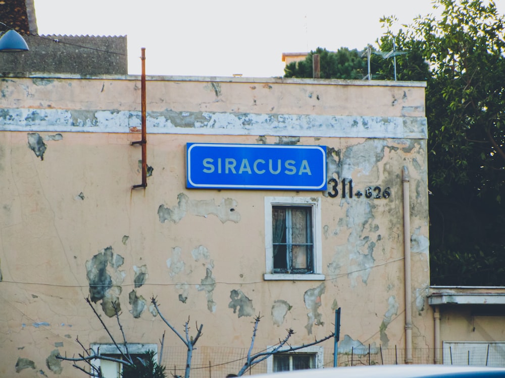 a blue street sign sitting on the side of a building