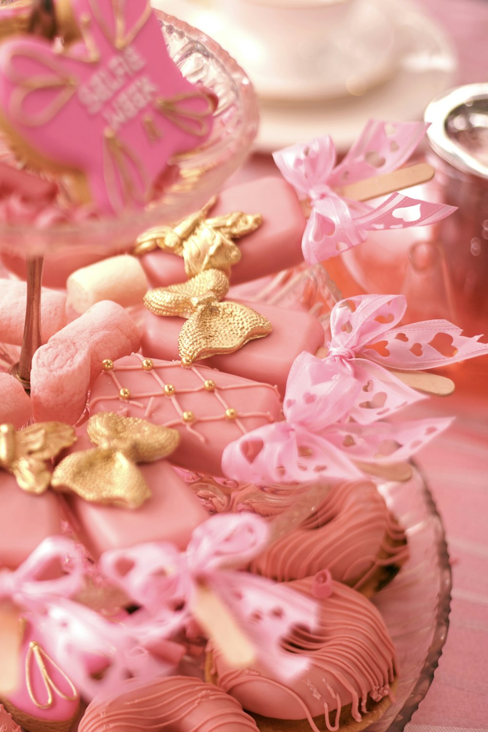 a pink and gold decorated cake on a table