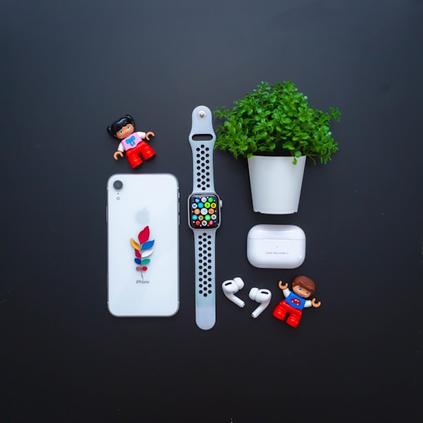 A flat lay of colorful phone accessories including chargers, earbuds, and phone grips arranged neatly on a wooden table.
