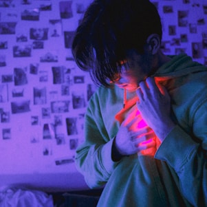 A heartfelt portrait of a person holding a camera, surrounded by vibrant images symbolizing rare diseases.