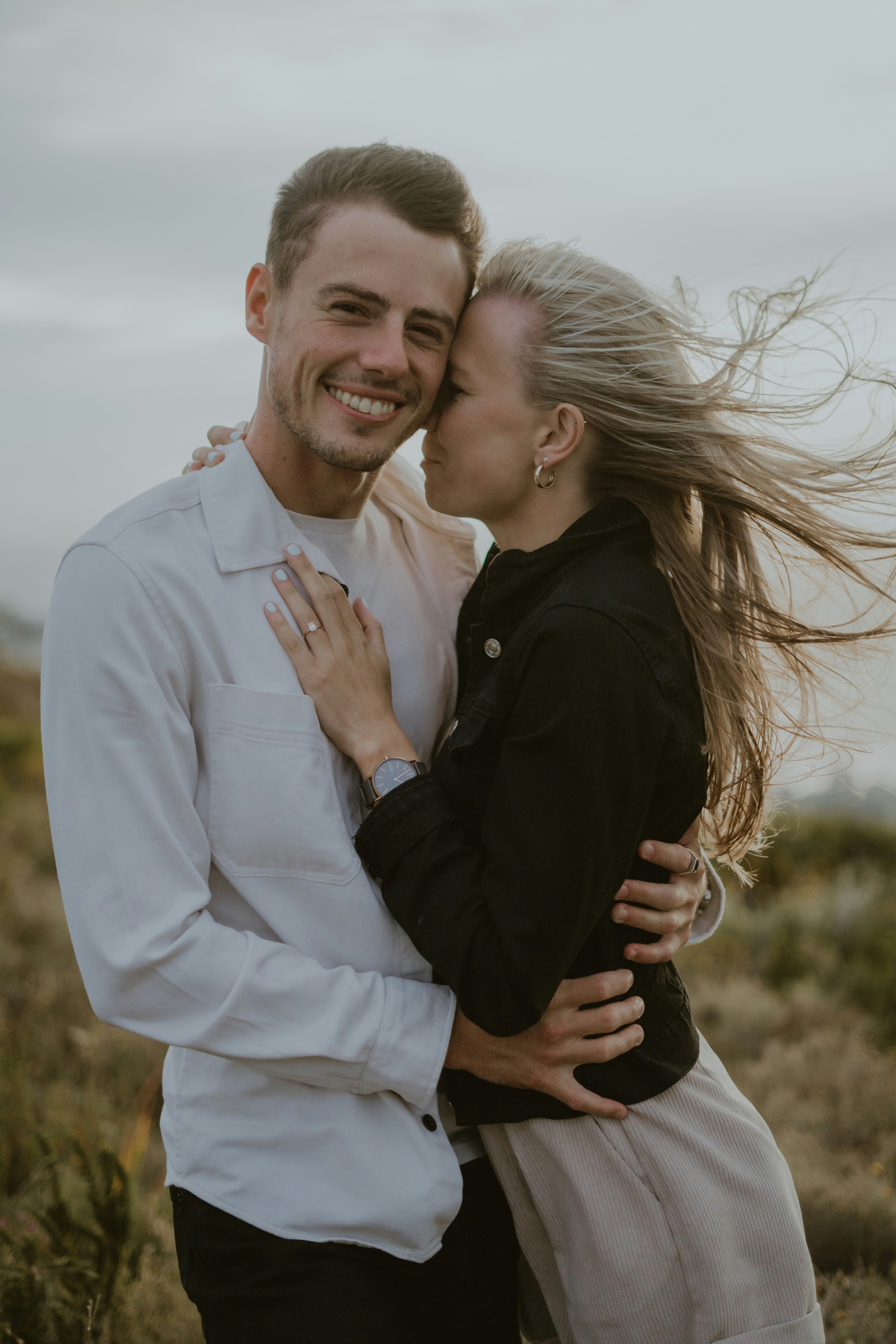 a man and a woman hugging in a field
