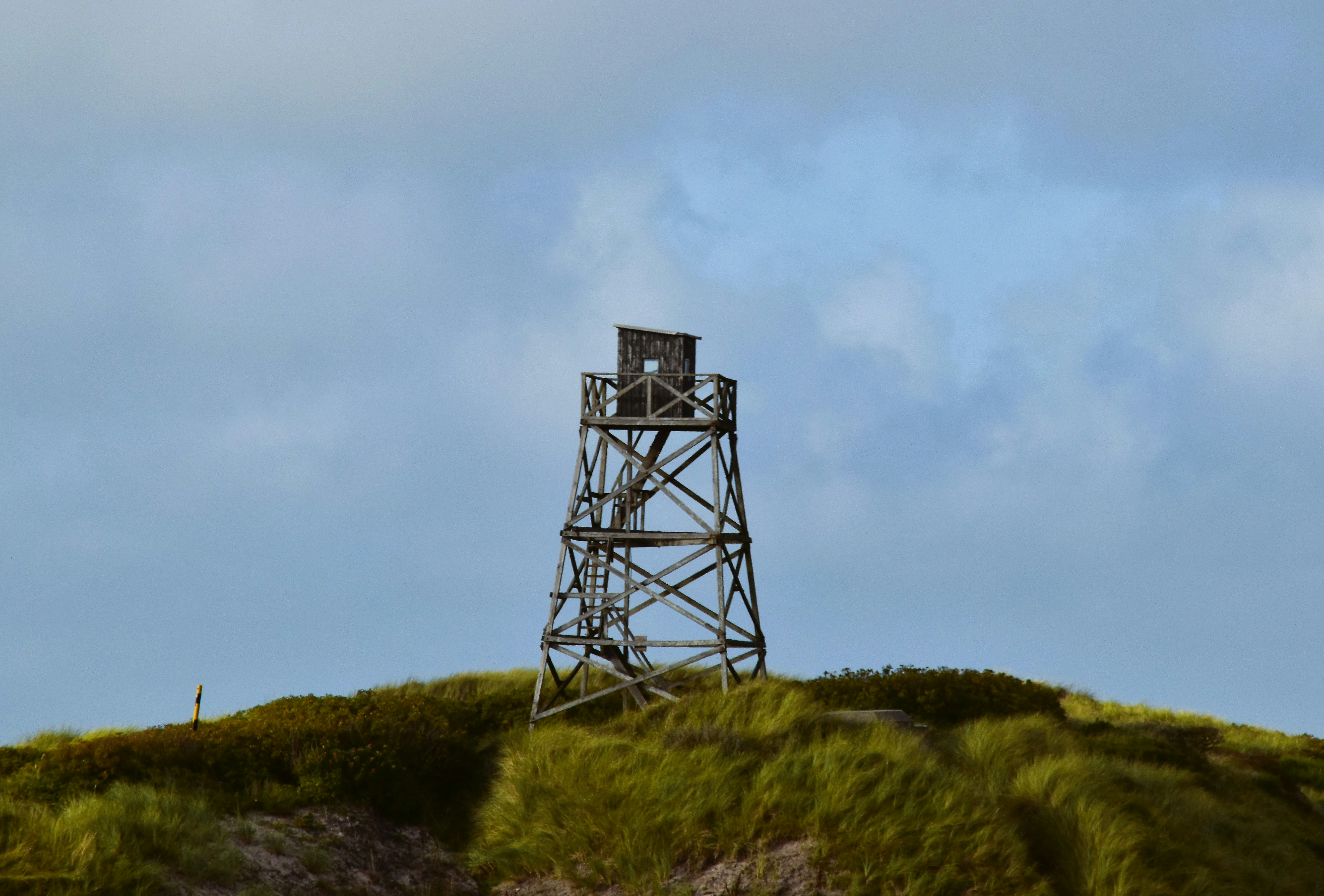 a tall tower sitting on top of a lush green hillside